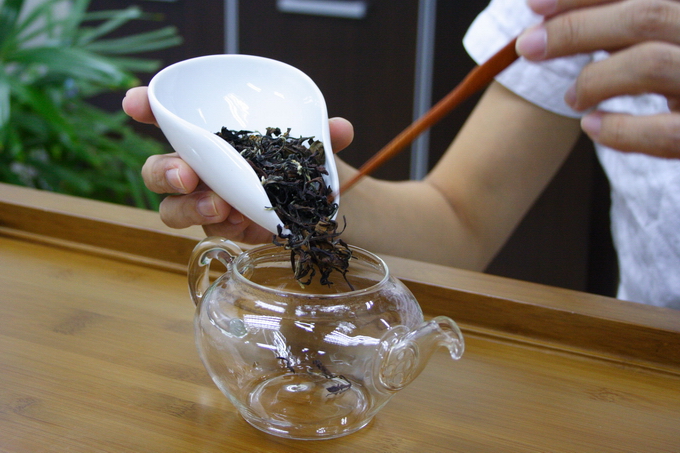 Place the tea leaves into the warmed tea pot. It is important not to touch the tea leaves in order to avoid the contamination of odor.