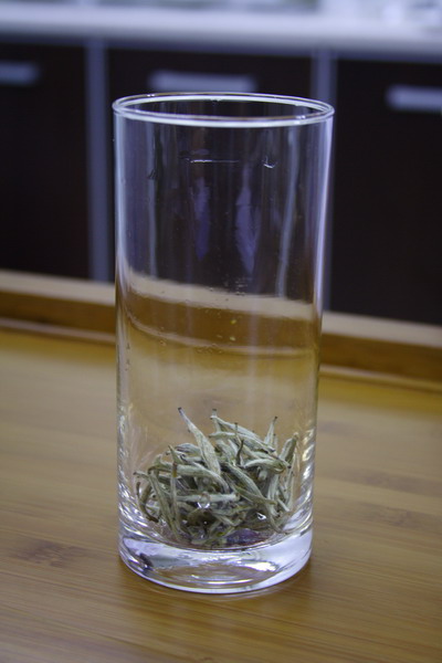 Tea leaves covers the bottom of glass.