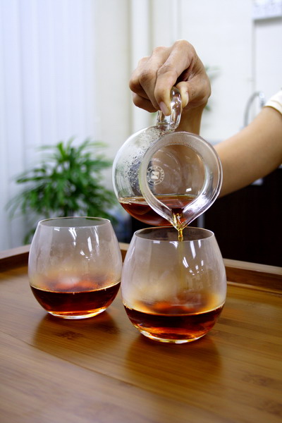 Pour tea from the right end which is supposed to be served for the guest. The one on the left is for the host.