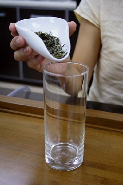 Place the tea leaves into the warmed glass. One could take precedence to smell the orchid fragrance of leaf liberated by the heat from warmed glass. Beforehand, it is important to warm the glass well by rinsing it out with boiled water. This should be done just before adding the tea leaves, so that leaves benefit from a gentle humid heat. It is important to maintain the water temperature when brewing for efficacious extraction of substances from leaf.