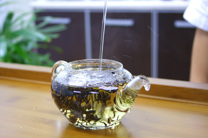 Pour in the hot water. Move the kettle up and down in order to agitates the tea leaves.