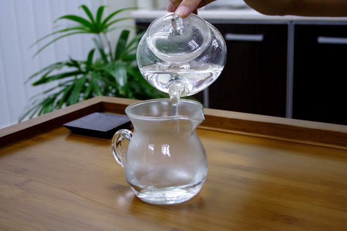 After 20 seconds, remove hot water from the warmed tea pot into the pitcher to warm it up.
