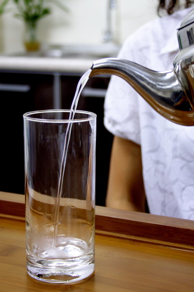 Pour the hot water into a long glass to warm it up.