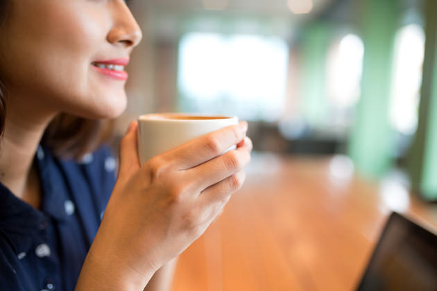 Portrait of attractive young asian woman drinking coffee